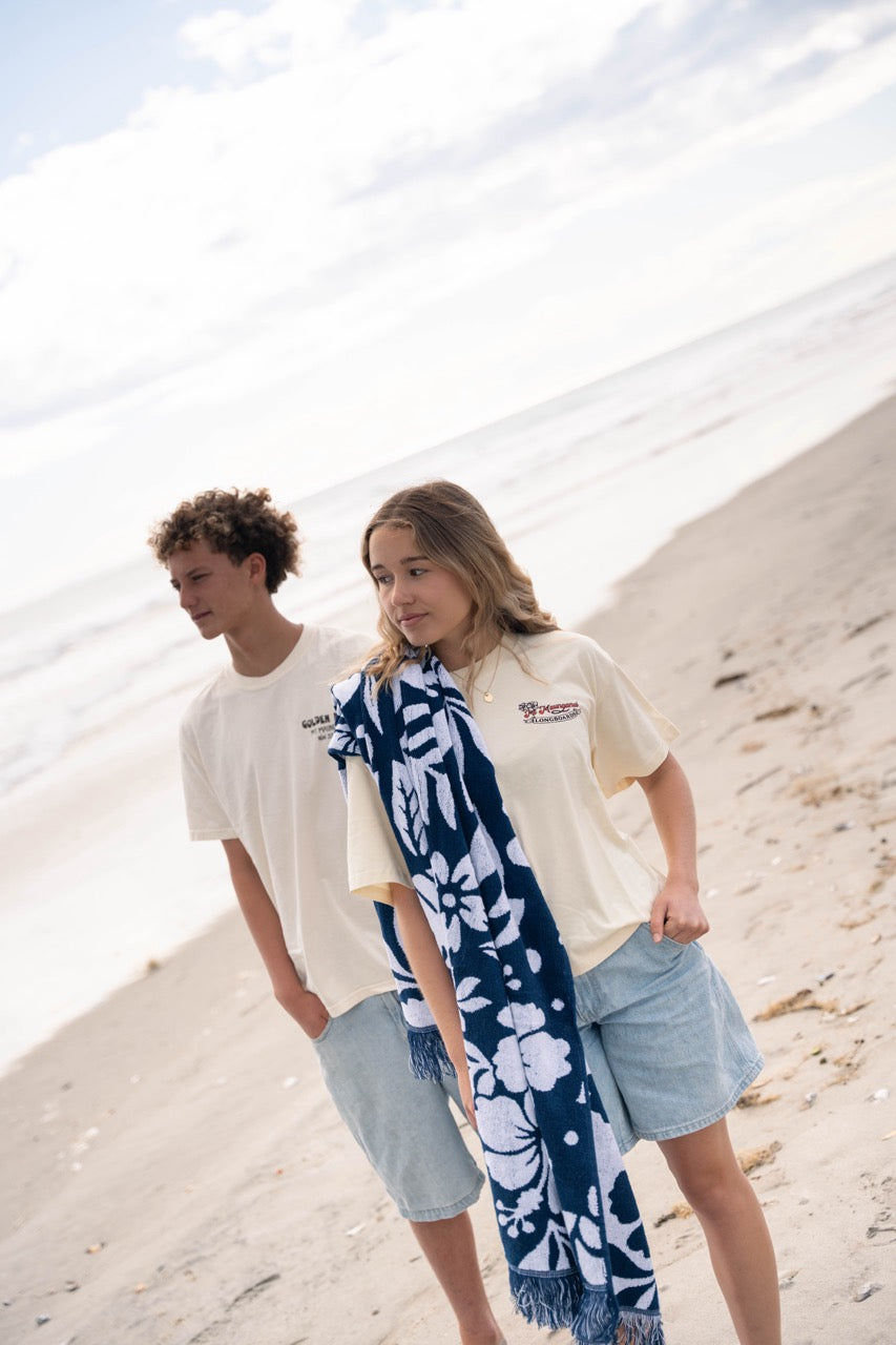 Oversized beach blanket with Retro motif in navy and white, featuring fringe edges.