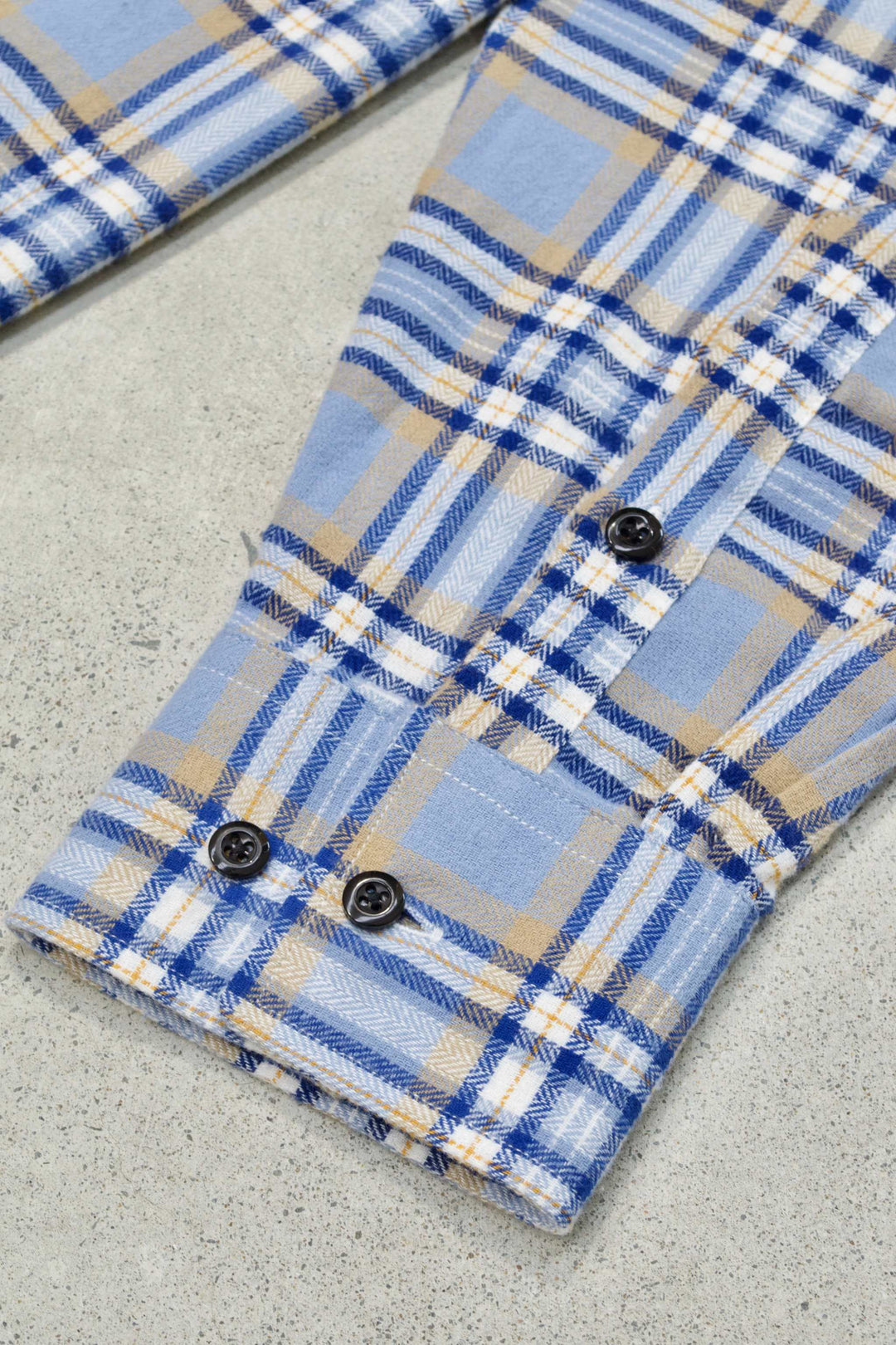 Blue plaid flannel shirt with buttoned cuffs, collared neckline, and embroidered details.