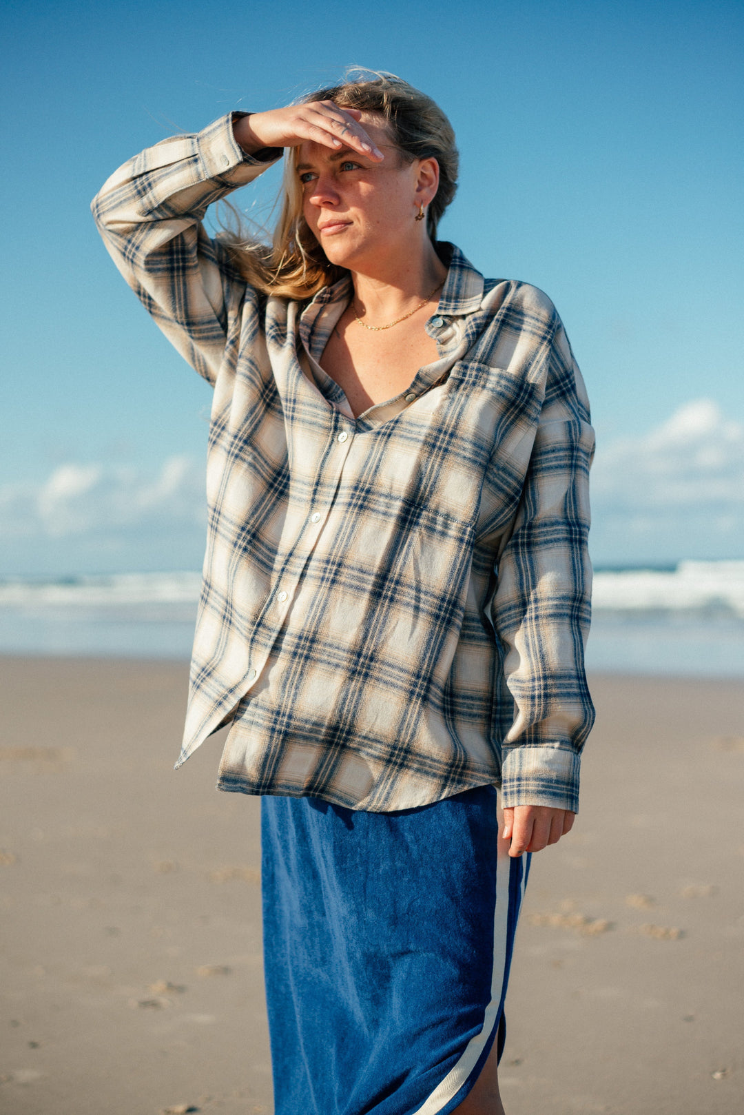 Atmosea Flannel Shirt in blue worn on the beach, featuring an oversized fit and 100% quality cotton.