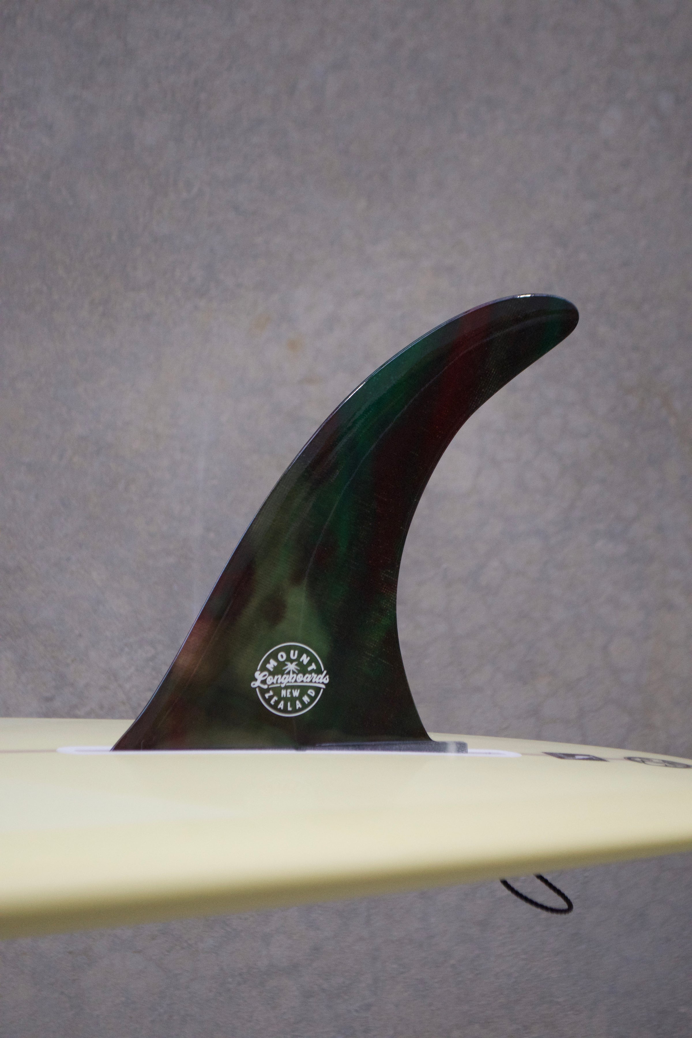 10" Greenstone Vibes Fin with groovy colors and polished finish on a surfboard.