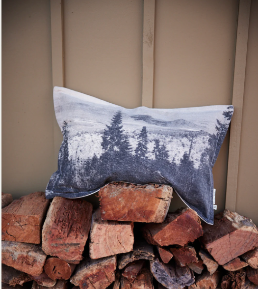 Black Forest Rectangle Cushion with forest print on firewood stack.