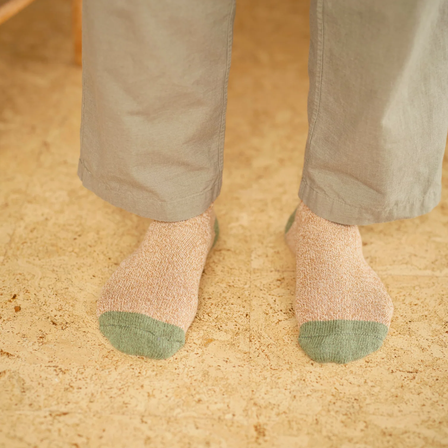 Utility Sock in beige with green accents, worn by person in gray pants, eco-friendly and preshrunk.